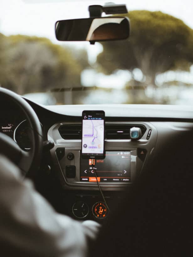 Rideshare driver with navigation attached to car dashboard